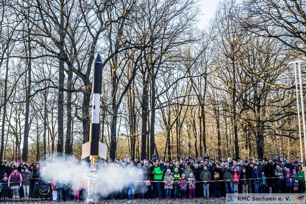 Eine Modellrakete hebt beim Silvesterstart vor den Zuschauern ab