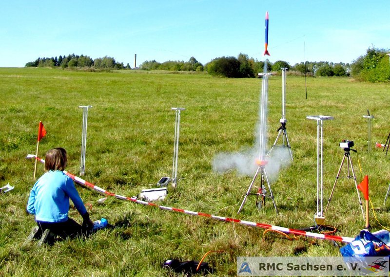 Start einer Wettbewerbsrakete auf einer Wiese mit mehreren Startrampen